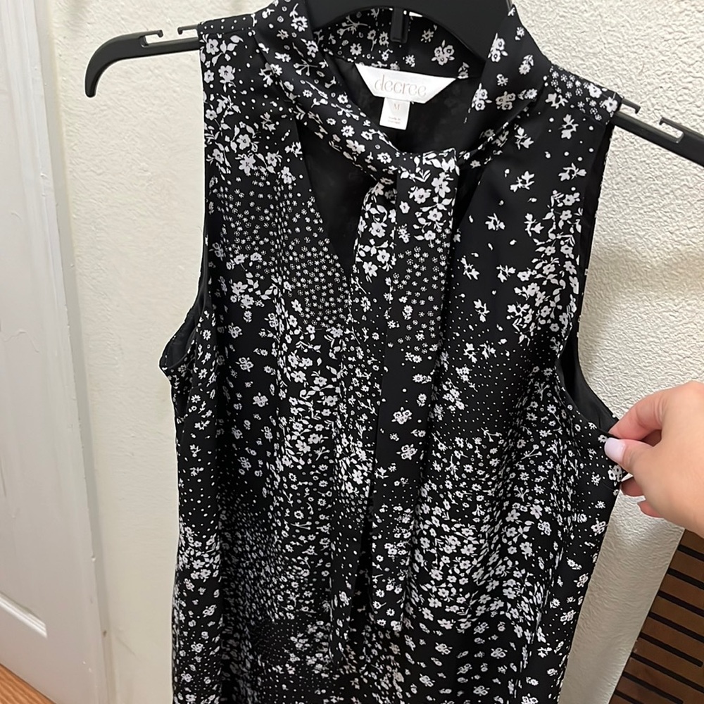 Sleeveless tunic with elegant neckline accent.